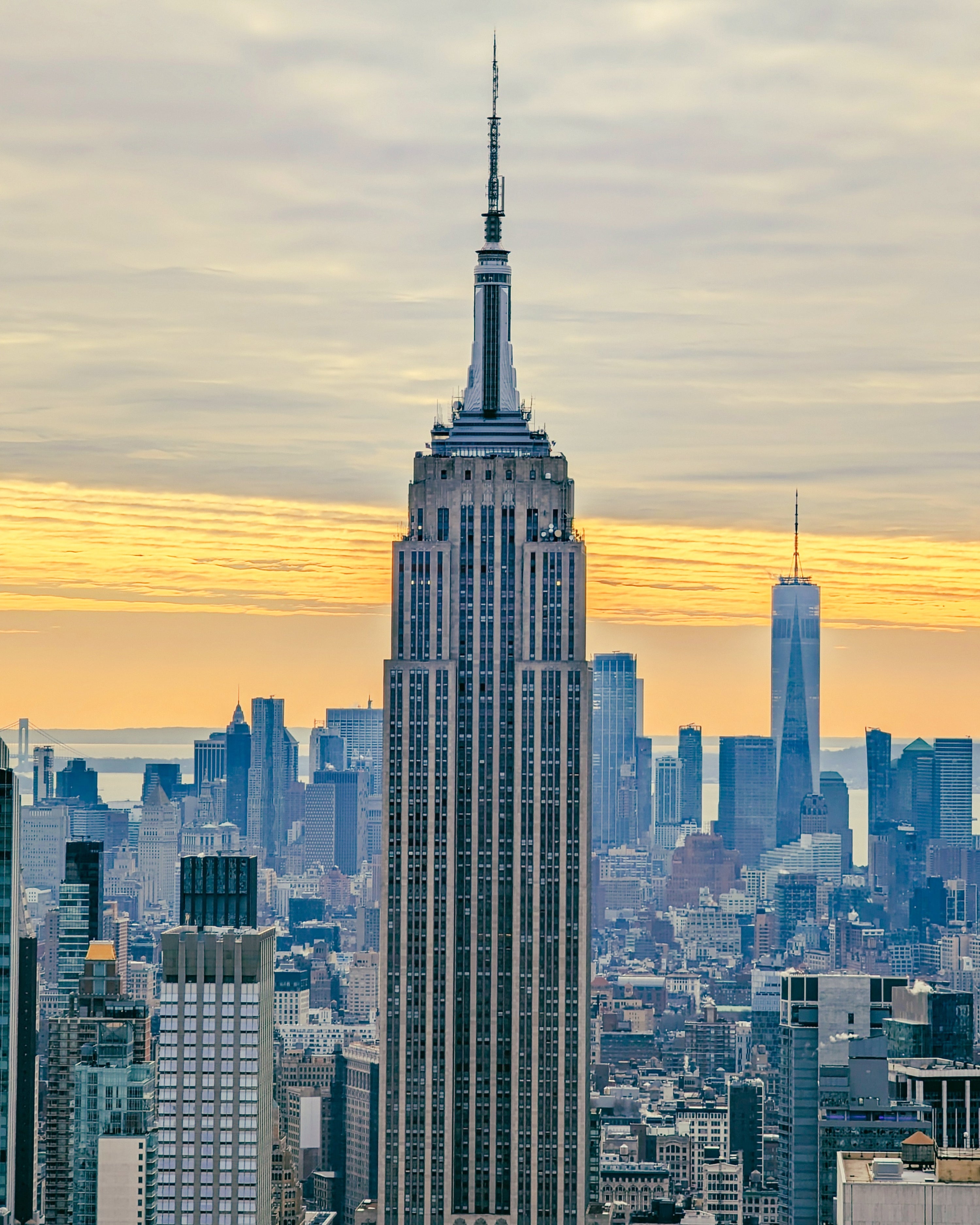 Close up of the Empire State Building with the city skyline at sunset in the background